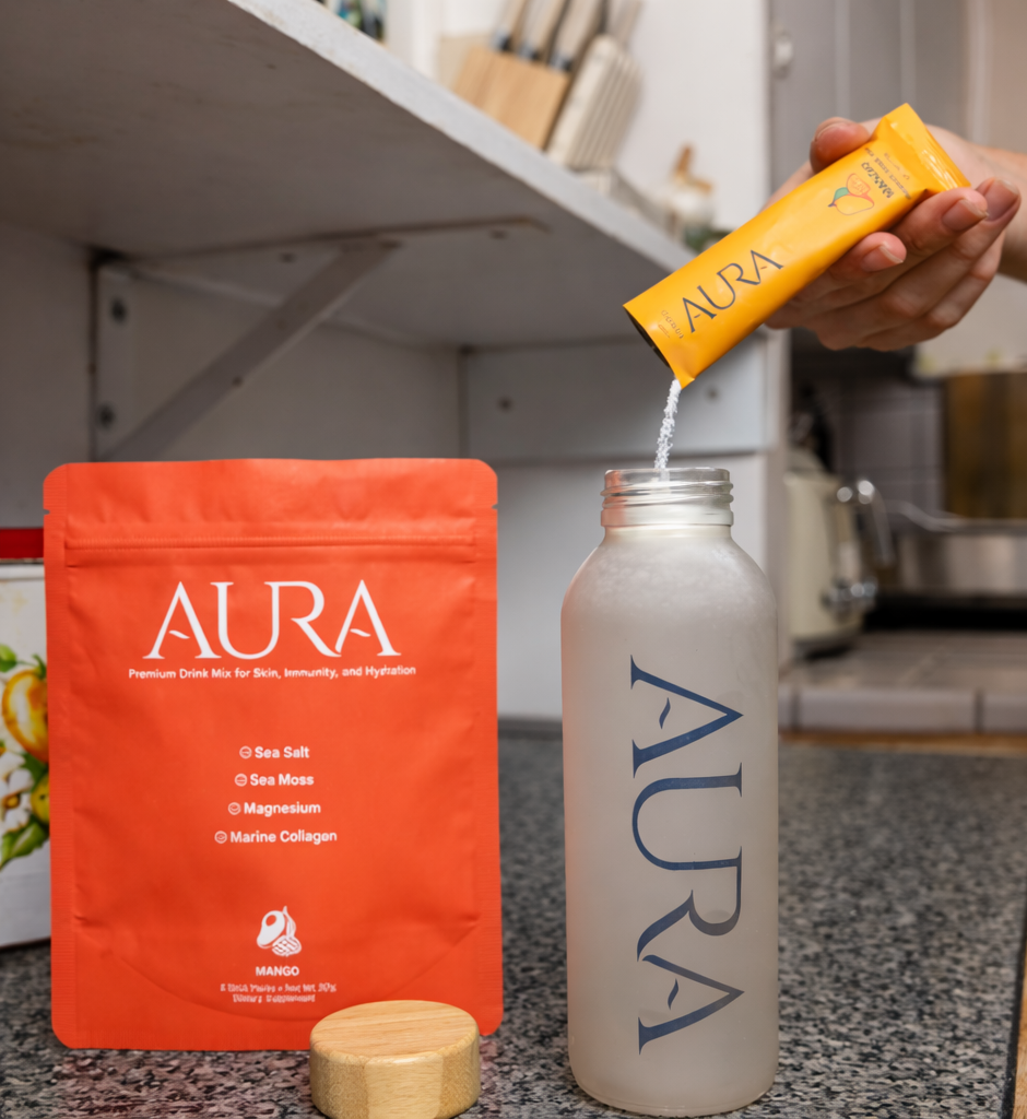 Person pouring Aura product into a bottle with packaging and a kitchen background